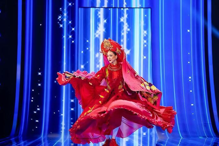 Diện trang phục nhuộm ngập sắc đỏ điểm tô họa tiết thêu chỉ vàng, người đẹp quê Hà Nội tỏa sáng trên sân khấu với màn xoay váy liên hoàn kết hợp múa quạt, giới thiệu văn hóa quê hương đến bạn bè quốc tế.
