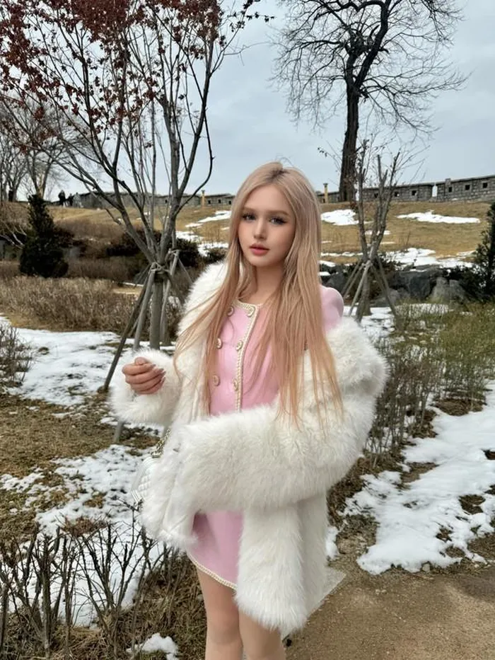 Diện set đồ bánh bèo màu hường phối với áo lông trắng, Xoài Non xinh đẹp, nổi bật giữa khung cảnh tuyết phủ trắng xung quanh